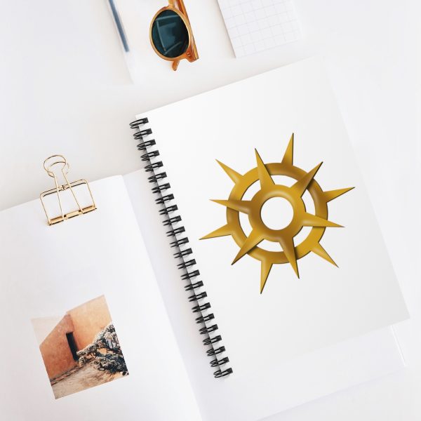 Spiral notebook with the symbol of Pelor, a gold sun burst, on desk