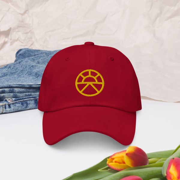 The symbol of Lathander, the DnD deity of renewal, a rising sun, on a red cranberry hat