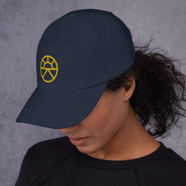 The symbol of Lathander, the DnD deity of renewal, a rising sun, on a navy blue hat angled
