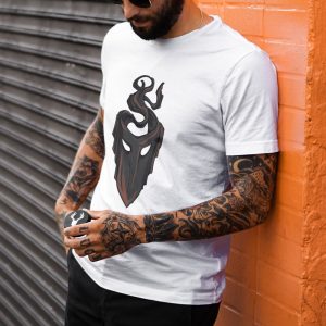 The symbol of mask, a black velvet mask, on a white shirt, on a man leaning against a wall