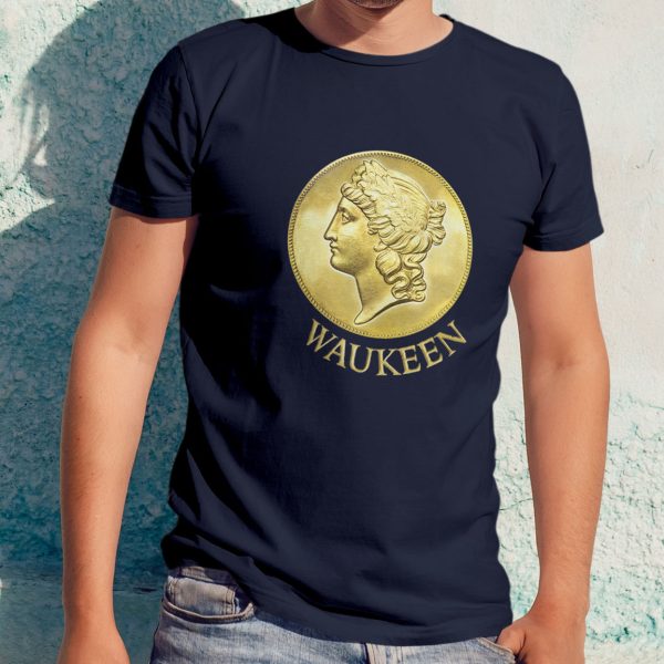 The DnD symbol of Waukeen, an upright coin with Waukeen’s profile facing left, on a navy blue shirt worn by a man leaning against a wall