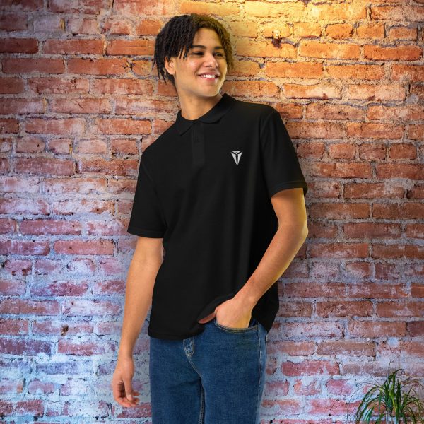 A black DnD polo shirt with the symbol of Asmodeus, Archdevil and the Prince of Hell. Worn by a man against a wall