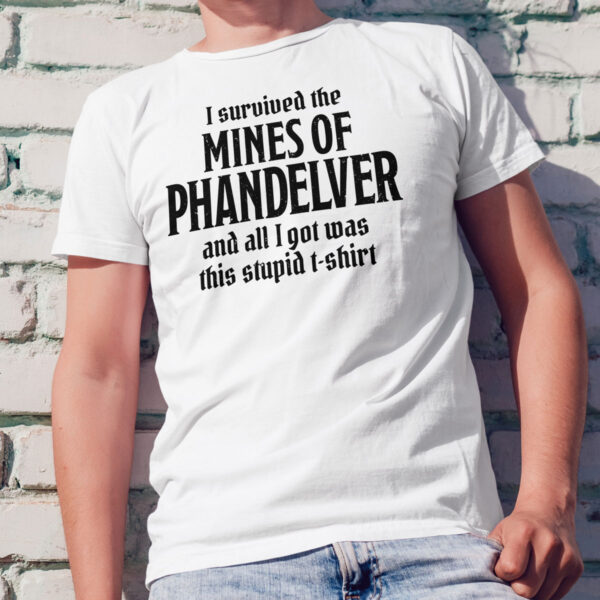 A white D&D shirt telling people that you survived the Mines of Phandelver, a D&D module, worn by a man against a wall