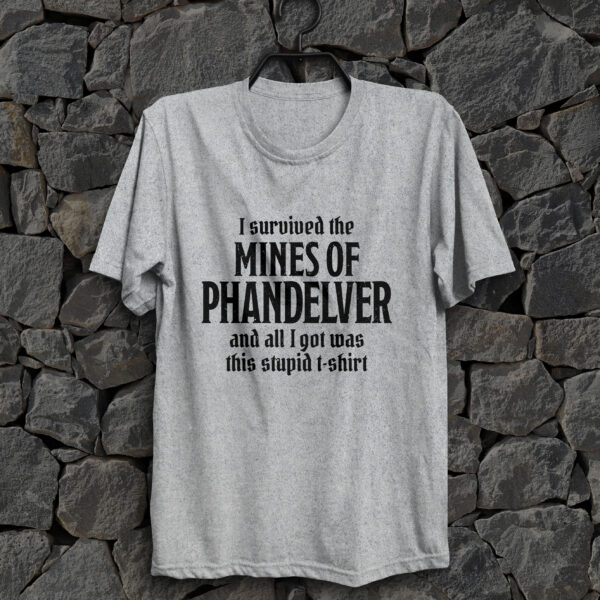 A sport gray D&D shirt telling people that you survived the Mines of Phandelver, a D&D module, against a stone wall