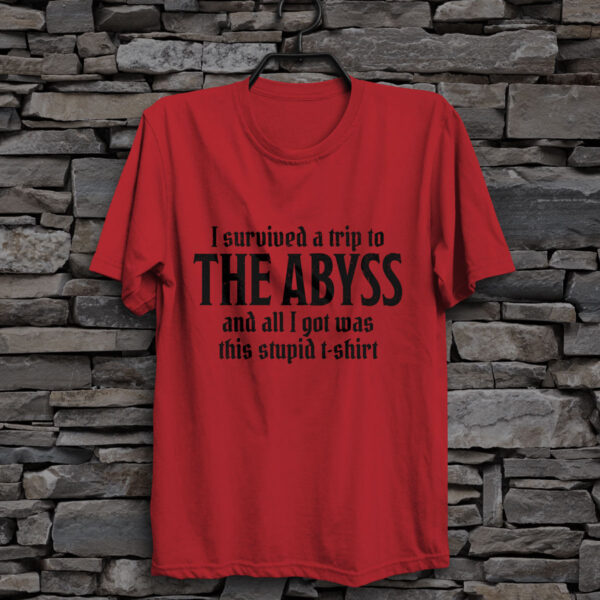 A red D&D shirt telling people that you survived the Abyss, a demonic realm in D&D, against a stone wall